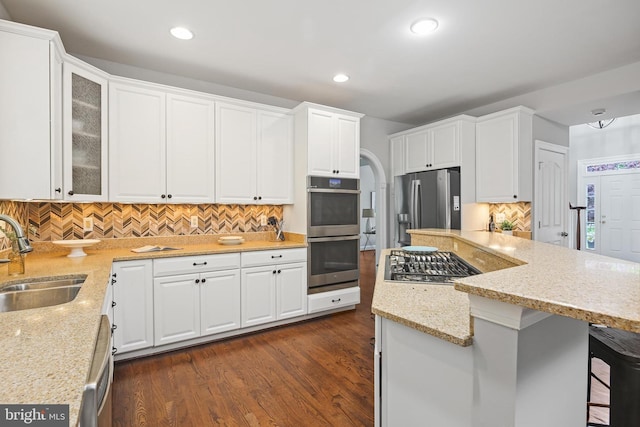 7098 Garden Walk, Columbia, MD 21044 - kitchen with a sink, stainless steel appliances, decorative backsplash, white cabinetry, and light stone countertops
