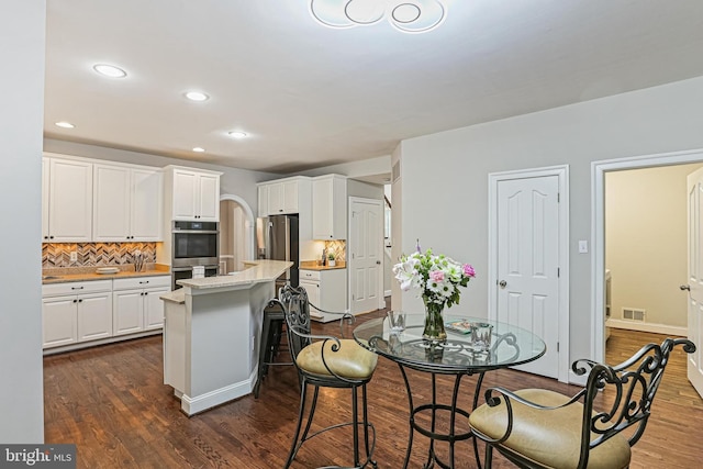 7098 Garden Walk, Columbia, MD 21044 - kitchen featuring stainless steel appliances, a center island, dark wood finished floors, white cabinets, and recessed lighting