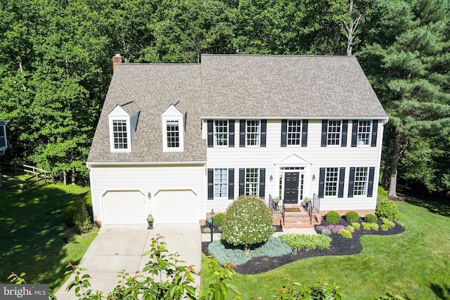 7098 Garden Walk, Columbia, MD 21044 - colonial house featuring a chimney, concrete driveway, a front lawn, a shingled roof, and a garage