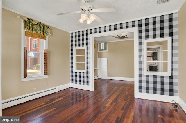 unfurnished room featuring crown molding, ceiling fan, baseboard heating, baseboards, and wood finished floors