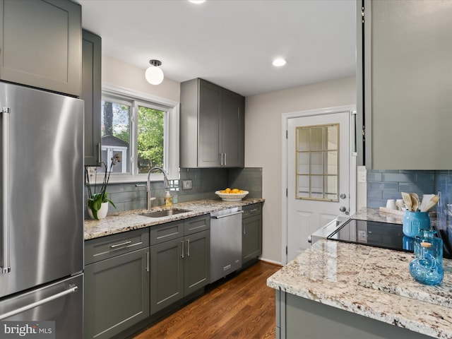 kitchen featuring dark wood-type flooring, a sink, appliances with stainless steel finishes, and tasteful backsplash