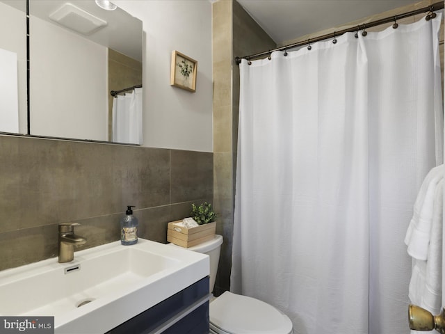 full bathroom with vanity, toilet, tile walls, a shower with shower curtain, and tasteful backsplash