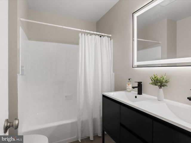 bathroom with a sink, toilet, double vanity, and shower / tub combo