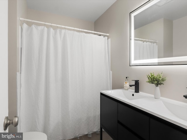 full bath with double vanity, a sink, and toilet