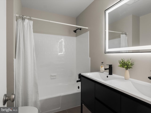 bathroom featuring a sink, shower / bath combo with shower curtain, toilet, and double vanity