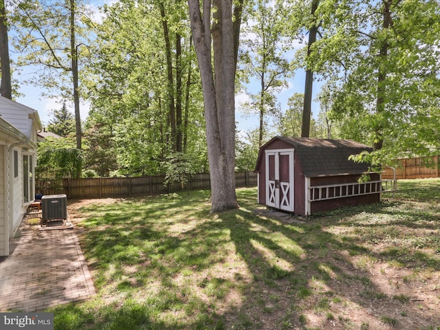 view of yard with a storage shed, central AC, an outdoor structure, and a fenced backyard
