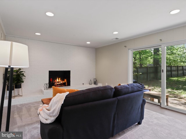 living room featuring crown molding, light colored carpet, a brick fireplace, recessed lighting, and visible vents