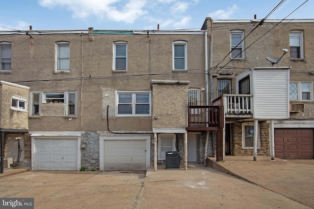 exterior space featuring a garage, central air condition unit, driveway, and stucco siding