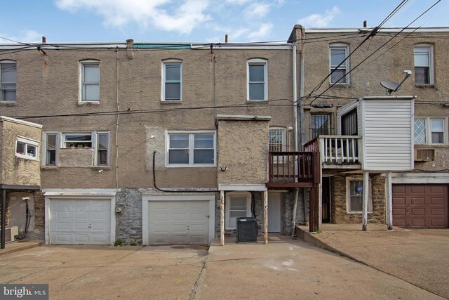 exterior space featuring a garage, central air condition unit, driveway, and stucco siding