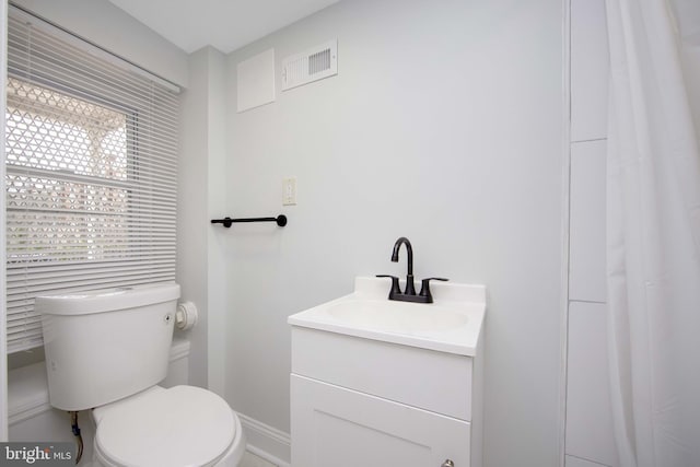 bathroom featuring baseboards, visible vents, vanity, and toilet