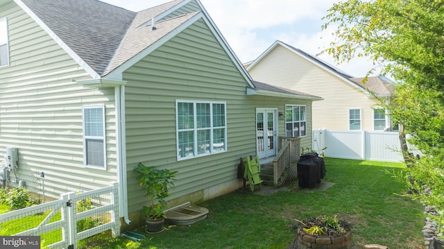 34795 Mute Swan Ln, Rehoboth Beach, DE 19971 - back of property with roof with shingles, a fenced backyard, and a lawn