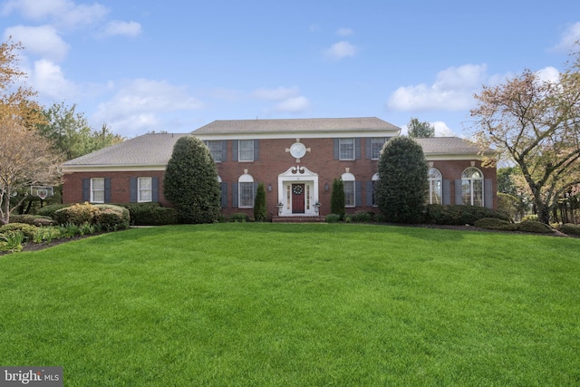 view of front of property featuring brick siding and a front yard