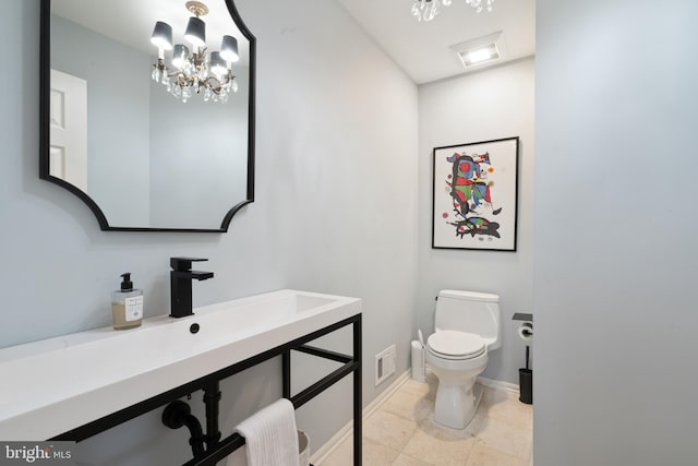 half bath with vanity, baseboards, toilet, a notable chandelier, and visible vents