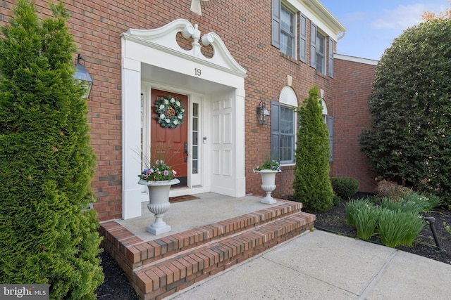 doorway to property with brick siding