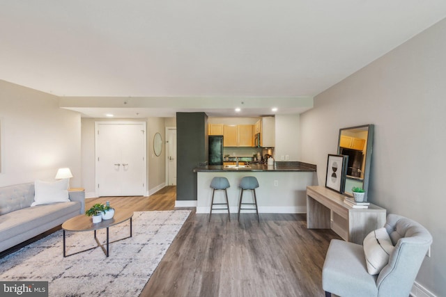 living area featuring recessed lighting, wood finished floors, and baseboards