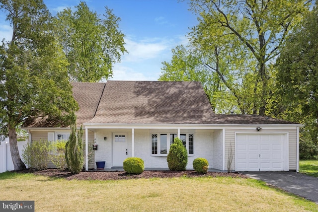 cape cod house with driveway, a front yard, and a garage