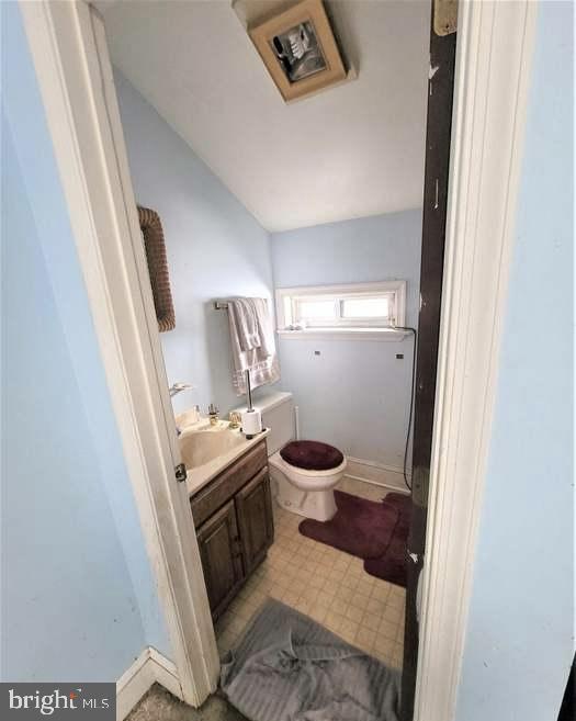 bathroom with vaulted ceiling, vanity, and toilet