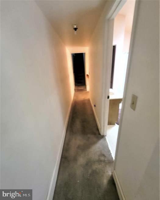 hallway with baseboards and carpet