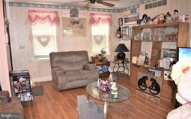 living room with ceiling fan, baseboards, wood finished floors, and visible vents