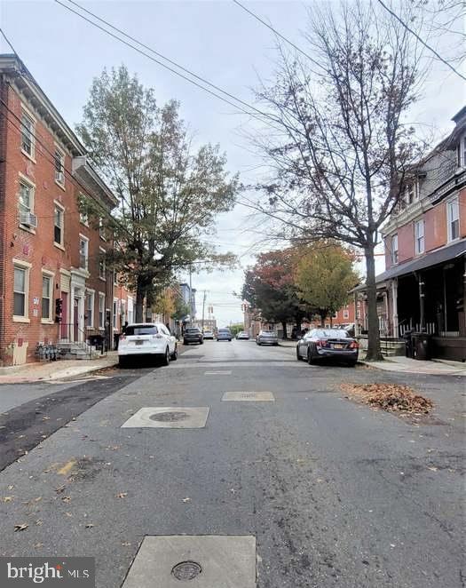 view of street with a residential view, sidewalks, and curbs