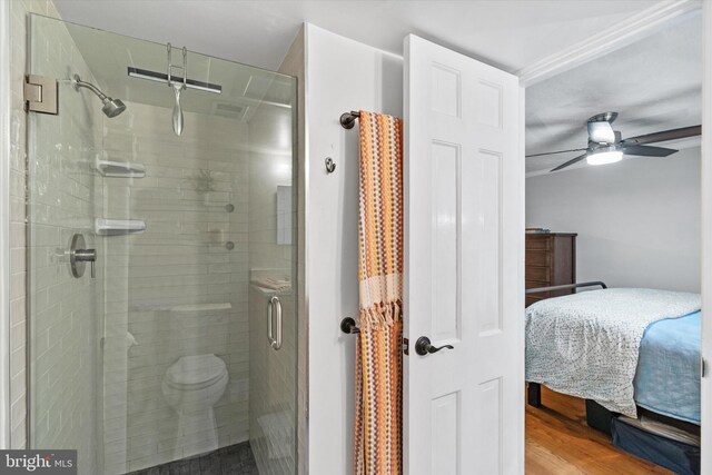 bathroom featuring wood finished floors, a shower stall, connected bathroom, and ceiling fan
