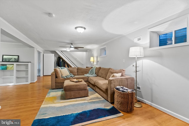 living area with visible vents, stairway, wood finished floors, and baseboards