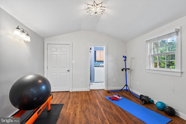 workout room featuring washer / dryer, lofted ceiling, wood finished floors, and baseboards