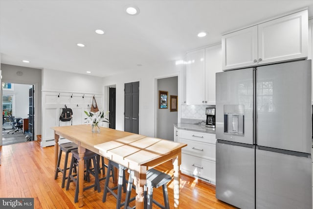 dining area featuring recessed lighting, light wood-style flooring, and baseboard heating