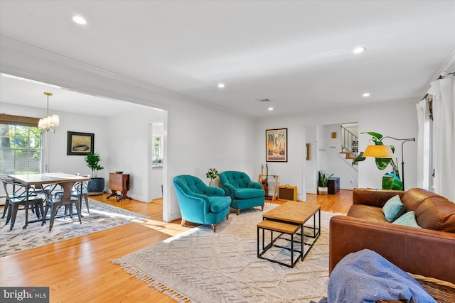 living area featuring stairway, wood finished floors, a notable chandelier, and recessed lighting