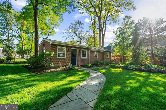 ranch-style house with a front lawn, fence, and brick siding