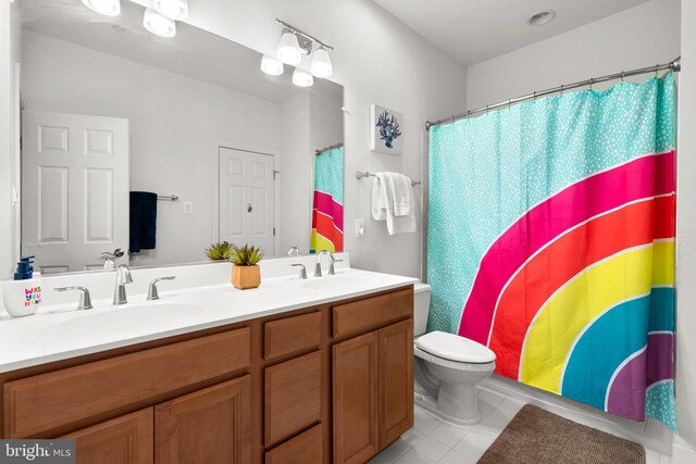 bathroom featuring tile patterned floors, a sink, double vanity, and toilet