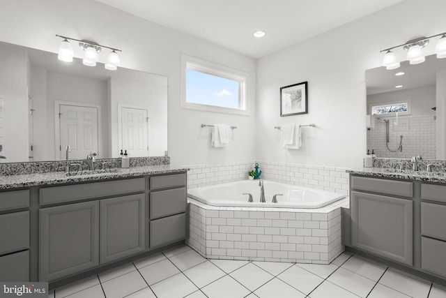 bathroom featuring plenty of natural light, a garden tub, a sink, and a shower stall