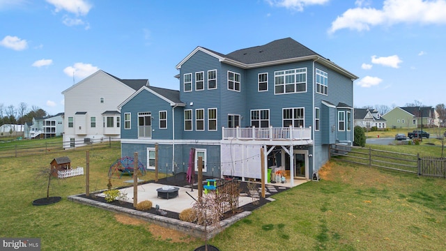rear view of house with a residential view, a fenced backyard, a fire pit, a yard, and a patio