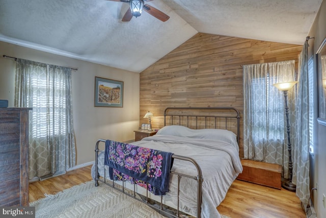 415 W High St, Felton, DE 19943 - bedroom with wood walls, a textured ceiling, wood finished floors, and lofted ceiling