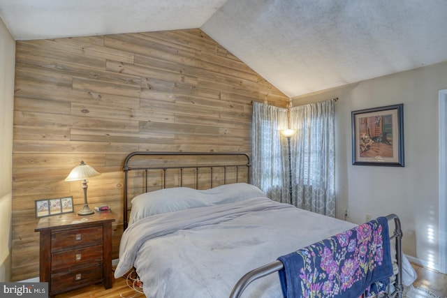 415 W High St, Felton, DE 19943 - bedroom with high vaulted ceiling, wood walls, and wood finished floors
