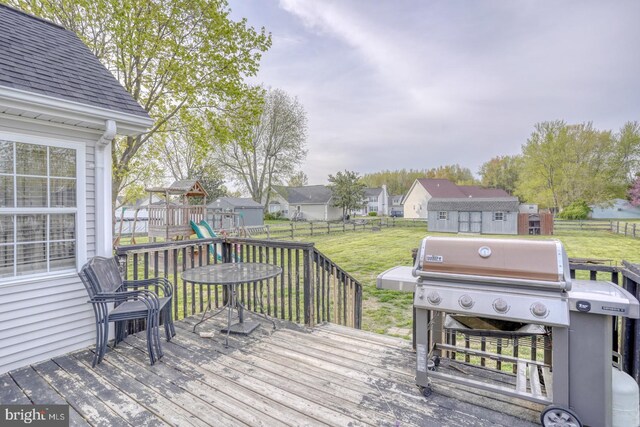 415 W High St, Felton, DE 19943 - wooden terrace featuring a fenced backyard, a yard, area for grilling, a residential view, and a playground