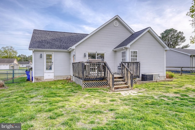 415 W High St, Felton, DE 19943 - rear view of house with fence, central air condition unit, a wooden deck, roof with shingles, and a lawn