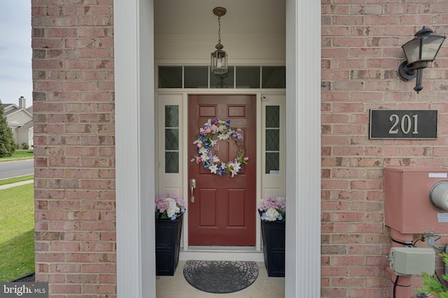 doorway to property featuring brick siding