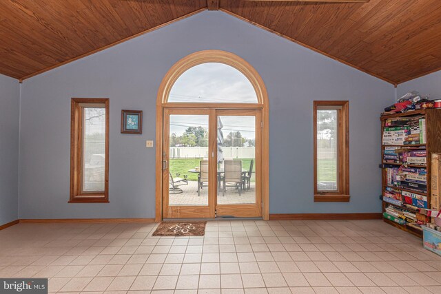 interior space with baseboards, lofted ceiling, a healthy amount of sunlight, and wood ceiling