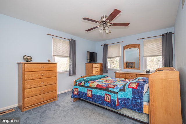 carpeted bedroom featuring baseboards, a ceiling fan, and visible vents