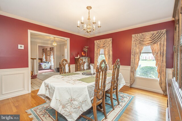 dining area with crown molding, a wainscoted wall, and a chandelier