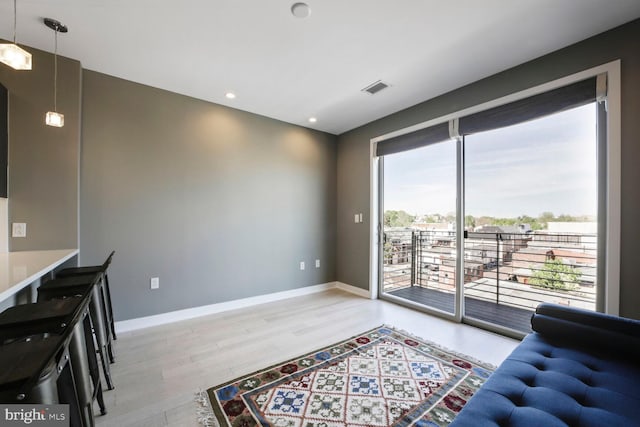 living room featuring light wood finished floors, recessed lighting, visible vents, and baseboards