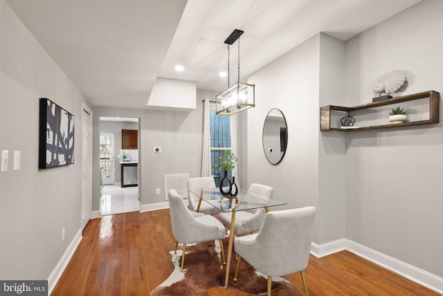dining area with a chandelier, wood finished floors, baseboards, and recessed lighting