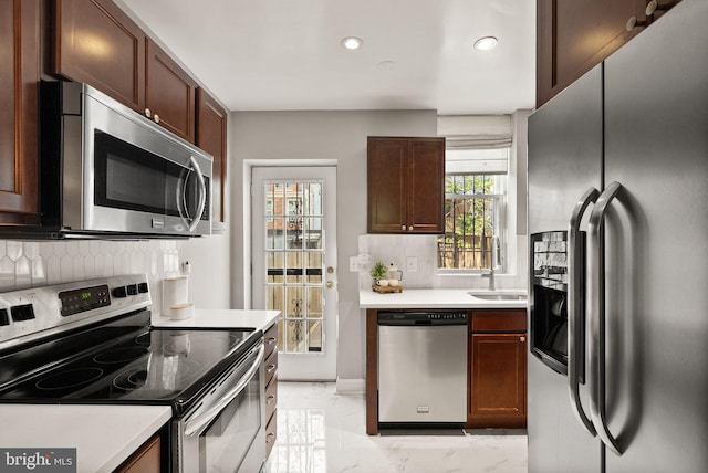 kitchen featuring tasteful backsplash, a sink, marble finish floor, appliances with stainless steel finishes, and recessed lighting
