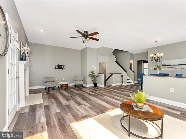 109 Rock Creek Ct, Frederick, MD 21702 - living room featuring stairs, baseboards, wood finished floors, and ceiling fan with notable chandelier