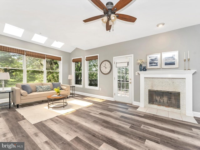 109 Rock Creek Ct, Frederick, MD 21702 - living area with lofted ceiling with skylight, wood finished floors, a ceiling fan, and baseboards