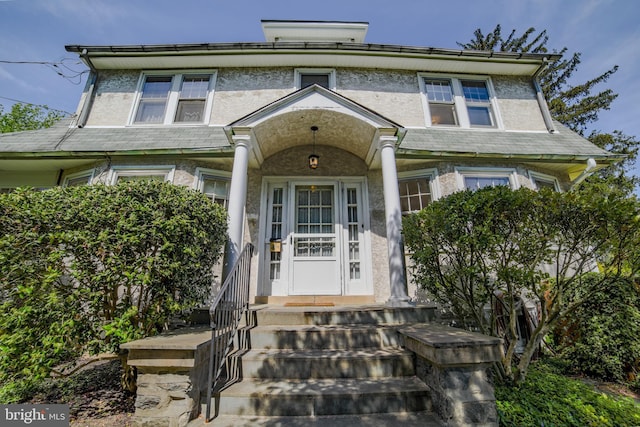 doorway to property featuring stucco siding