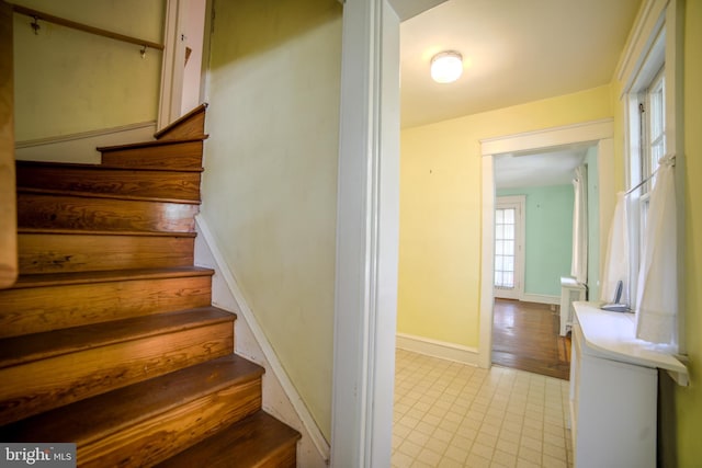 staircase with baseboards and tile patterned floors