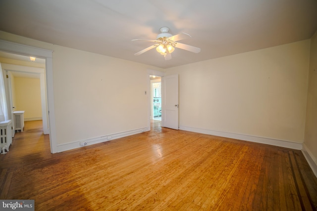 empty room with baseboards, ceiling fan, and light wood-type flooring