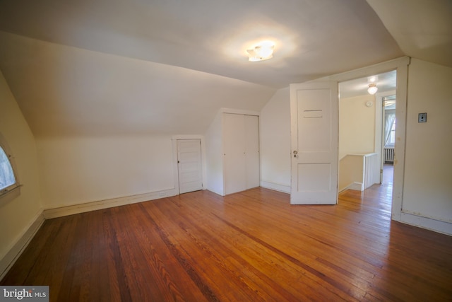 bonus room with baseboards, vaulted ceiling, and hardwood / wood-style floors